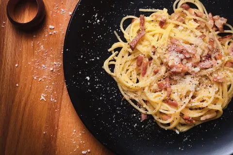 Un plat de spaghetti carbonara, prêt à être dégusté. Une recette italienne authentique, simple et savoureuse.