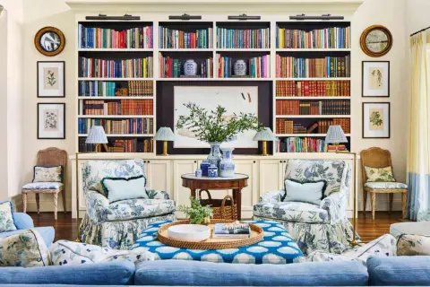 Ideas on how to decorate a bookshelf: a cozy living room with built-in shelves filled with books, art, and decorative vases.