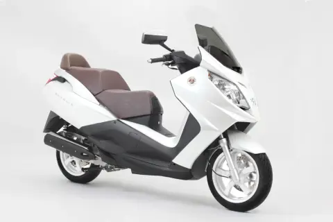 Biały skuter Peugeot Satelis z brązową kanapą, gotowy na miejskie podróże.