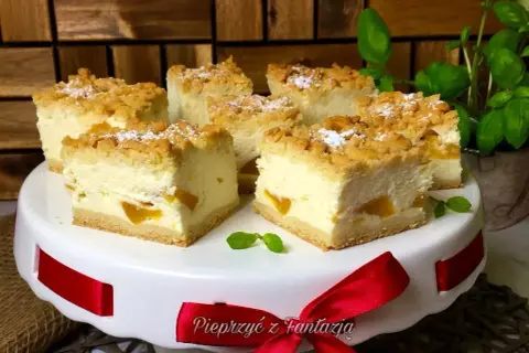 Pyszny sernik z brzoskwiniami przepis. Kremowe ciasto z owocami i kruszonką, idealne na deser.