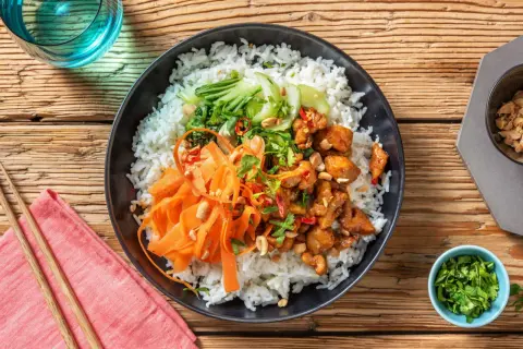 En läcker donburi med kyckling, ris, strimlad morot, pak choi och jordnötter.