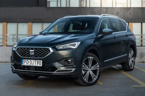 Ciemnozielony SUV z dużym bagażnikiem, zaparkowany na zewnątrz.