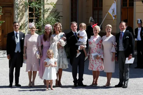 Familie feiert Taufe. Elegante Outfits, die zeigen, was zur Taufe anziehen: zarte Pastelltöne und festliche Kleider.
