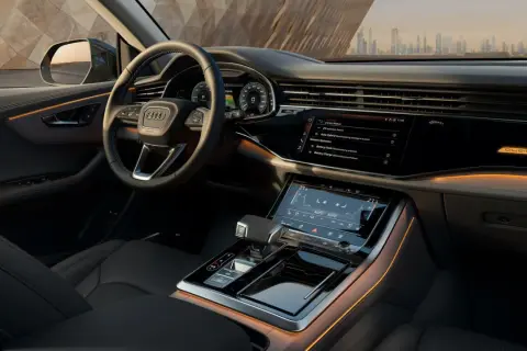 Interni lussuosi dell'Audi Q8 con illuminazione ambientale e schermi digitali.