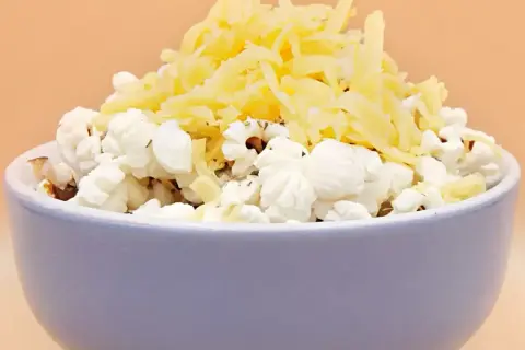Miseczka popcornu z tartym serem. Pyszna przekąska, ale warto pamiętać o jej popcorn kcal.