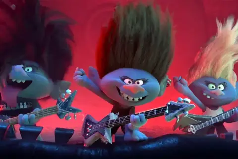 Trzy trolle rockmani grają na gitarach, tworząc głośne trolle piosenki. Ich włosy sterczą, a mina wyraża rock'n'rollową energię.
