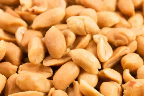 Un mucchio di arachidi tostate, perfette per uno snack salutare. Quante arachidi al giorno sono ideali per un'alimentazione equilibrata?