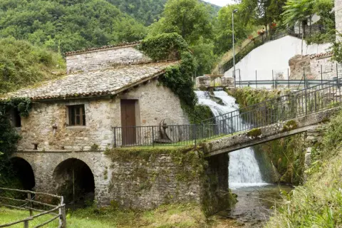 Antico mulino in pietra con cascata e ponte a Pieve Torina. Un luogo suggestivo da scoprire, tra natura e storia.