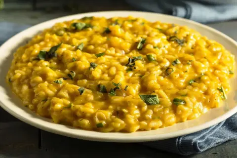 Cremiges, goldgelbes Risotto, garniert mit frischen Kräutern. Ein klassisches Risotto Rezept, das Lust auf mehr macht.