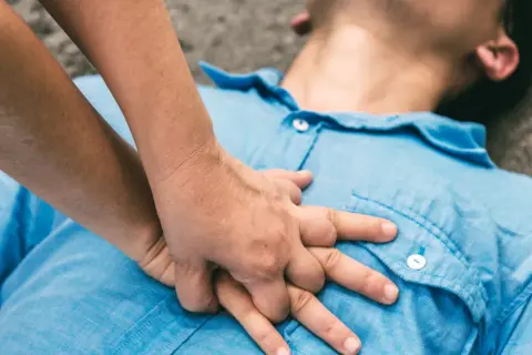 Dłonie wykonują uciski klatki piersiowej, ratując życie. To RKO.