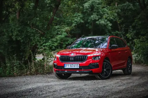 Czerwona Skoda Kamiq na leśnej drodze. Wiele osób szuka skoda kamiq opinie, by poznać ten model.