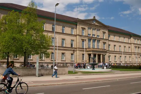Großes Universitätsgebäude mit Brunnen und Studenten. Hier kann man Zahnmedizin studieren.