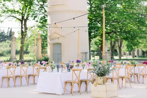 Une belle allée de mariage extérieur, décorée de tables dressées, de fleurs et de guirlandes lumineuses, invite à la célébration.