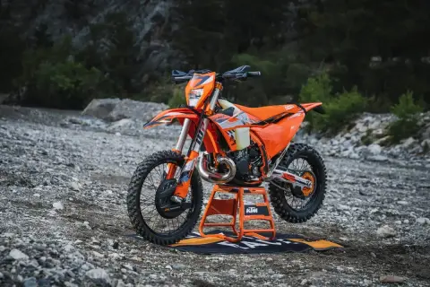 Pomarańczowy KTM EXC 300 2T na stojaku, gotowy do jazdy w terenie. Sprawdź jego dane techniczne!