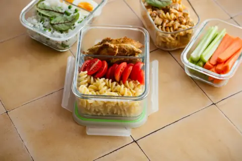Zastanawiasz się, ile kosztuje dieta pudełkowa? Oto przykładowe posiłki: makaron z kurczakiem i pomidorkami, ryż z jajkiem i groszkiem, warzywa.