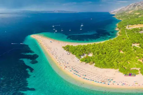 Zlatni Rat, jedna z najpiękniejszych plaż w Europie, z turkusową wodą i sosnowym lasem.
