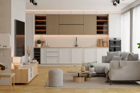 Nowoczesny salon z aneksem kuchennym. Jasne meble, wygodna kanapa i drewniane akcenty tworzą przytulną atmosferę.