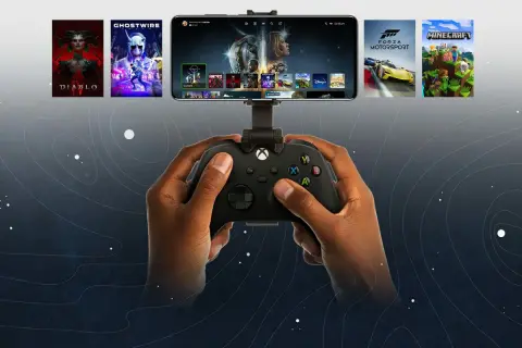 Dłonie trzymające kontroler Xbox, na ekranie smartfona widoczne gry z Xbox Cloud Gaming.