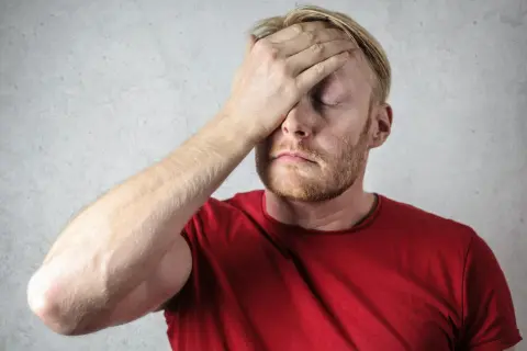 Hombre con mano en la frente, parece que no sabe qué hacer.