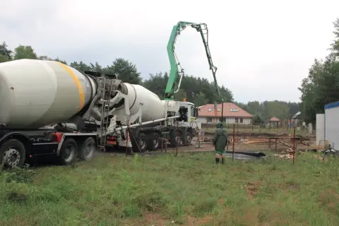 Betoniarka z wysięgnikiem pompuje beton. To jak zrobić beton w wiadrze, tylko na większą skalę.