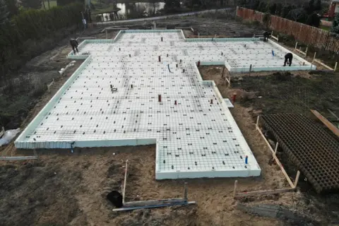 Budowa fundamentów pod taras z wykorzystaniem bloczków betonowych i zbrojenia.