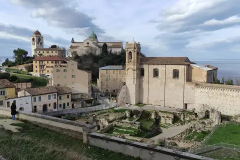 Panoramica del capoluogo Marche con antiche rovine, chiese e il mare all'orizzonte.
