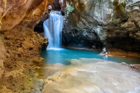 Cascada en una cueva, ideal para excursiones cerca de Zaragoza con agua cristalina y formaciones rocosas.