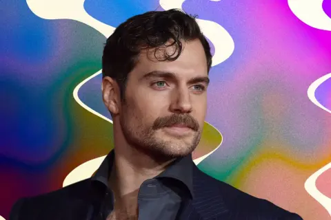 Un homme au regard intense, sa moustache parfaitement taillée, sur un fond abstrait aux couleurs vives.