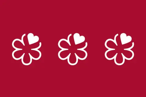 Tres flores blancas con un corazón en cada una, sobre fondo rojo. Símbolo de excelencia culinaria, como en restaurantes con 4 estrellas Michelin.