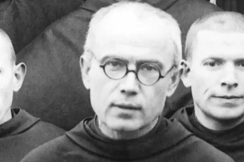 Trzej zakonnicy w habitach. W środku Maksymilian Kolbe w okularach. Ciekawostki o jego życiu i heroizmie.