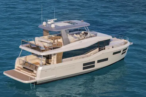 Un lussuoso yacht elettrico bianco naviga su acque blu, con ampi ponti e comode aree salotto.