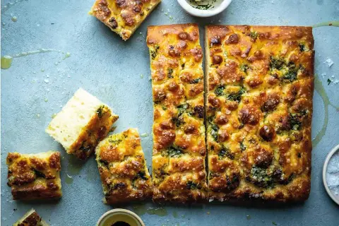 En gyllene focaccia långpanna, skuren i bitar, med örter och flingsalt. Perfekt för en mysig fika.
