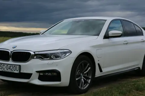 Białe BMW 530 na tle burzowego nieba. Elegancka limuzyna z polskimi tablicami rejestracyjnymi SC 0420U.
