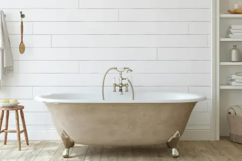 Bagno moderno con vasca da bagno color sabbia, rubinetteria dorata e asciugamani bianchi. Un progetto di verniciare vasca da bagno per un look rinnovato.