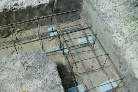 Zbrojenie wieńca w narożu fundamentu, gotowe do zalania betonem. Stalowe pręty tworzą solidną konstrukcję.