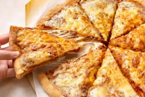 Gotowe ciasto na pizzę z ciągnącym serem, które aż prosi się, by je zjeść. Idealne na szybki obiad.