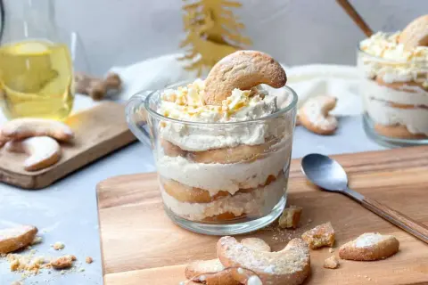 Schichtdessert im Glas mit Keksen und Sahne, garniert mit Schokostreuseln. Ein festliches Dessert, das zum Genießen einlädt.