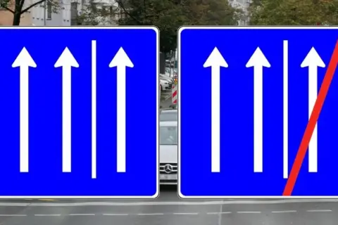 Verkehrsschilder zeigen drei Fahrspuren geradeaus. Rechts endet die rechte Spur, die man nicht mehr befahren darf.