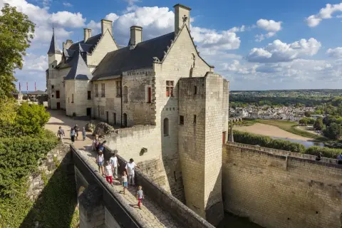 Visiteurs sur le pont menant au château de Chinon. Renseignez-vous sur le château de Chinon tarif pour votre visite.