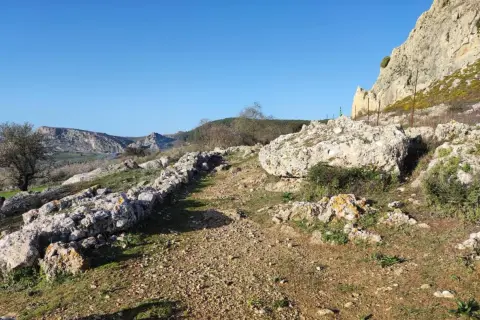 Senderos rocosos y vegetación agreste invitan a explorar qué hacer en Carboneras, con imponentes formaciones rocosas al fondo.