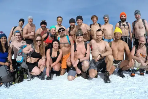 Grupa morsów z Polski, zahartowana metodą Wim Hof, pozuje do zdjęcia na śniegu.