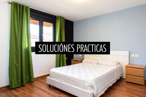 Habitación con cama blanca y cortinas verdes. Descubre feng shui consejos para un hogar armonioso.