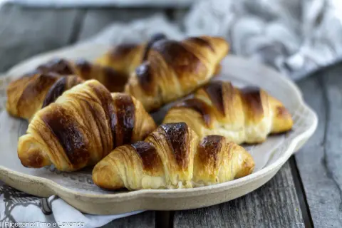 Une assiette de croissants italiens dorés et feuilletés, prêts à être dégustés.