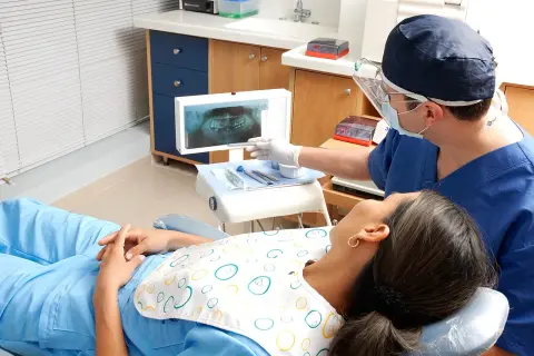 Dentysta omawia z pacjentką zdjęcie RTG, szukając rozwiązań co zamiast leczenia kanałowego.