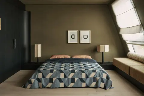 Dormitorios pequeños con cama geométrica, lámparas de diseño y un banco tapizado junto a la ventana.