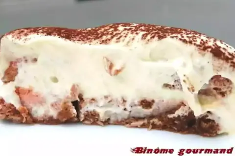 Tranche de tiramisu crémeux, parsemé de cacao, avec des morceaux de biscuit rose. Un délice !