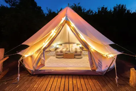 Mysig glampingtält med säng och belysning, redo för en vistelse på nynäshamn camping.
