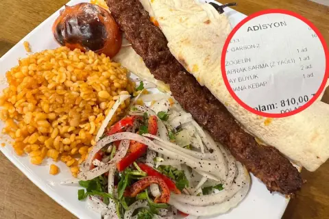 Talerz z daniem kebab, ryżem, sałatką i rachunkiem z ceną 810,00.