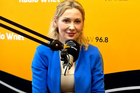 Joanna Miziołek, w wieku około 40 lat, w niebieskiej marynarce, udziela wywiadu w Radiu Wnet.