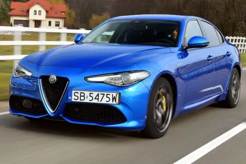 Niebieskie Alfa Romeo Giulia w ruchu. Wiele pozytywnych alfa romeo giulia opinie potwierdza jej sportowy charakter.